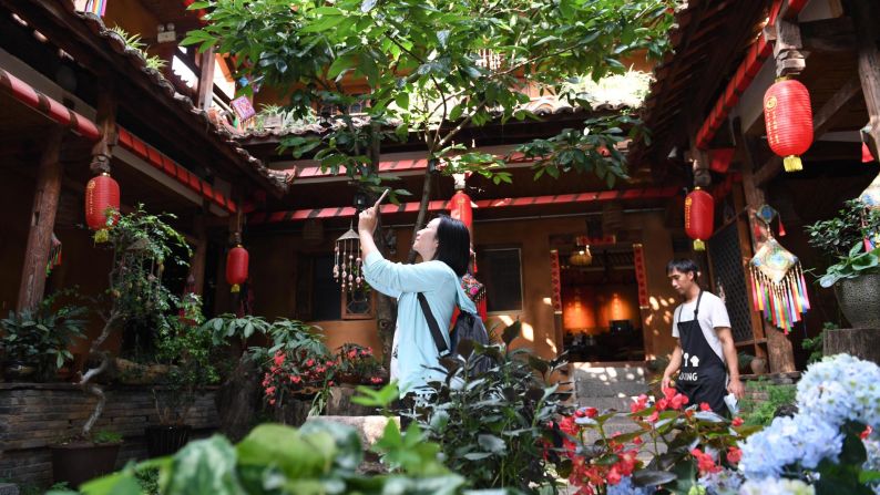 <strong>Rural tourism: </strong>A tourist takes photos at a family-run hostel in Xianrendong village in southwest China's Yunnan province. Residents here have shaken off poverty by developing rural tourism, which takes advantage of natural resources within the Puzhehei scenic area. 