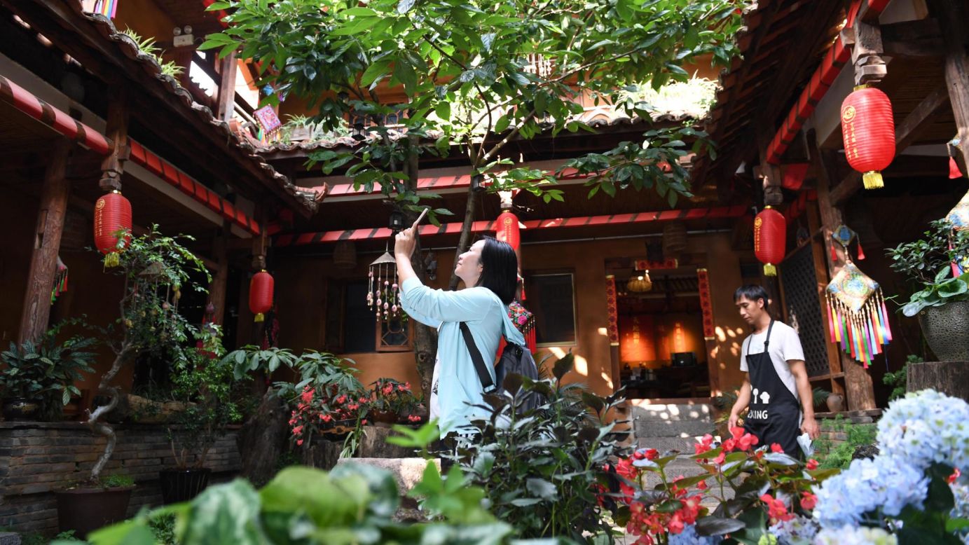 <strong>Rural tourism: </strong>A tourist takes photos at a family-run hostel in Xianrendong village in southwest China's Yunnan province. Residents here have shaken off poverty by developing rural tourism, which takes advantage of natural resources within the Puzhehei scenic area. 