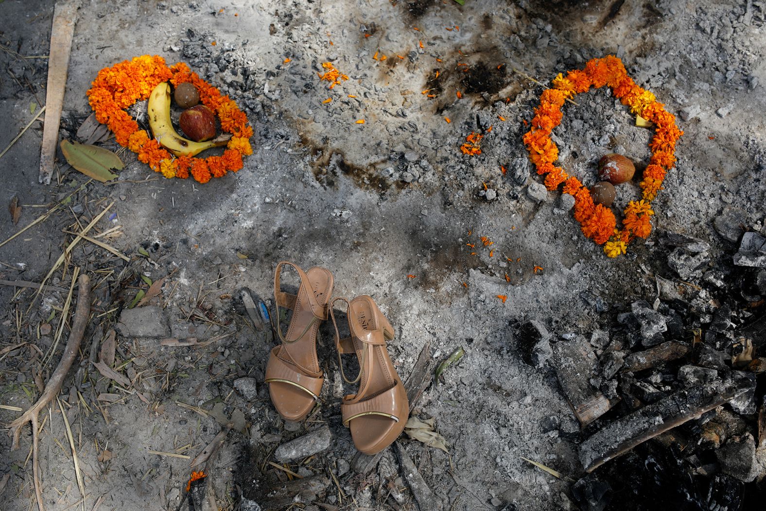 Flower garlands, fruits and a pair of sandals were placed on a spot where a woman was cremated in New Delhi on April 30. 