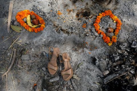 Flower garlands, fruits and a pair of sandals were placed on a spot where a woman was cremated in New Delhi on April 30. 
