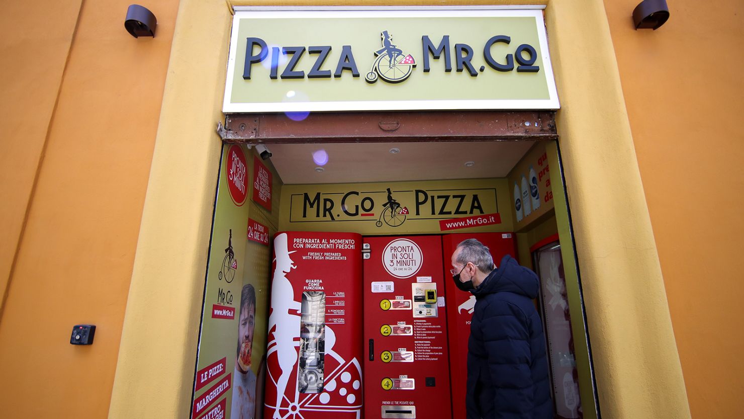Claudio Zampiga waits for his order at the first automatic pizza vending machine, which is capable of kneading, seasoning and cooking the pizza in three minutes, in Rome, Italy, May 6, 2021. REUTERS/Yara Nardi