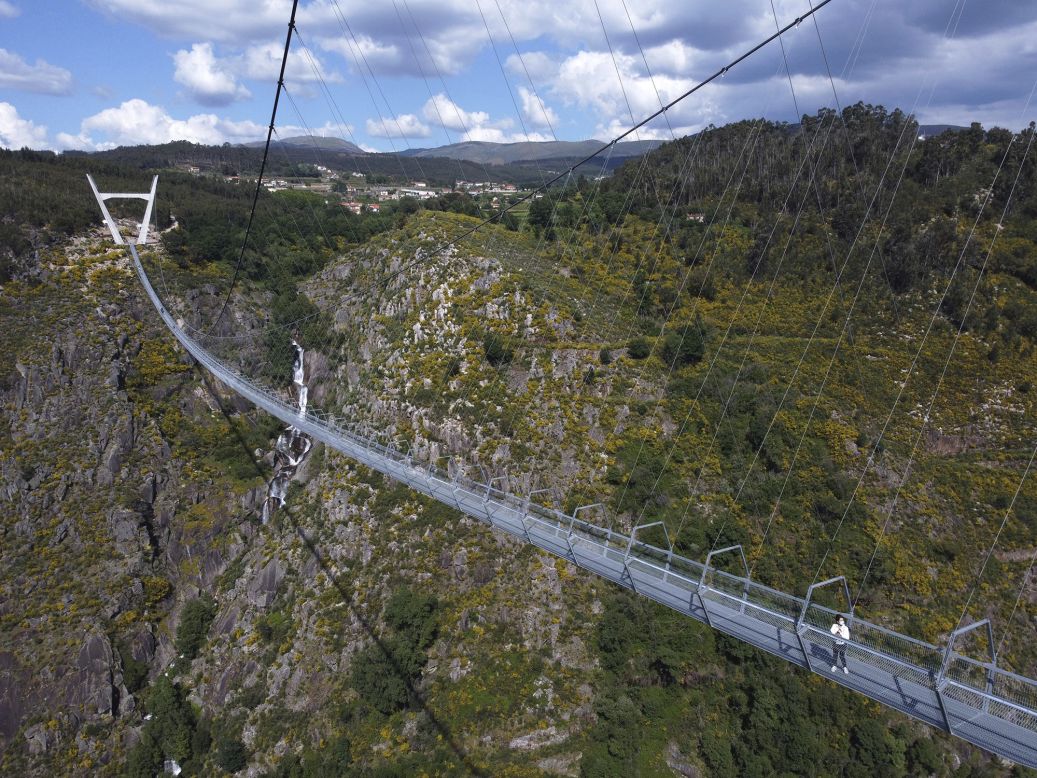 People walk across 516 Arouca, <a href="https://www.cnn.com/travel/article/world-longest-pedestrian-suspension-bridge-portugal-arouca/index.html" target="_blank">the world's largest pedestrian suspension bridge,</a> in Arouca, Portugal, on Sunday, May 2. The new bridge is 516 meters long (1,692 feet), and it connects the Aguieiras Waterfall to Paiva Gorge.