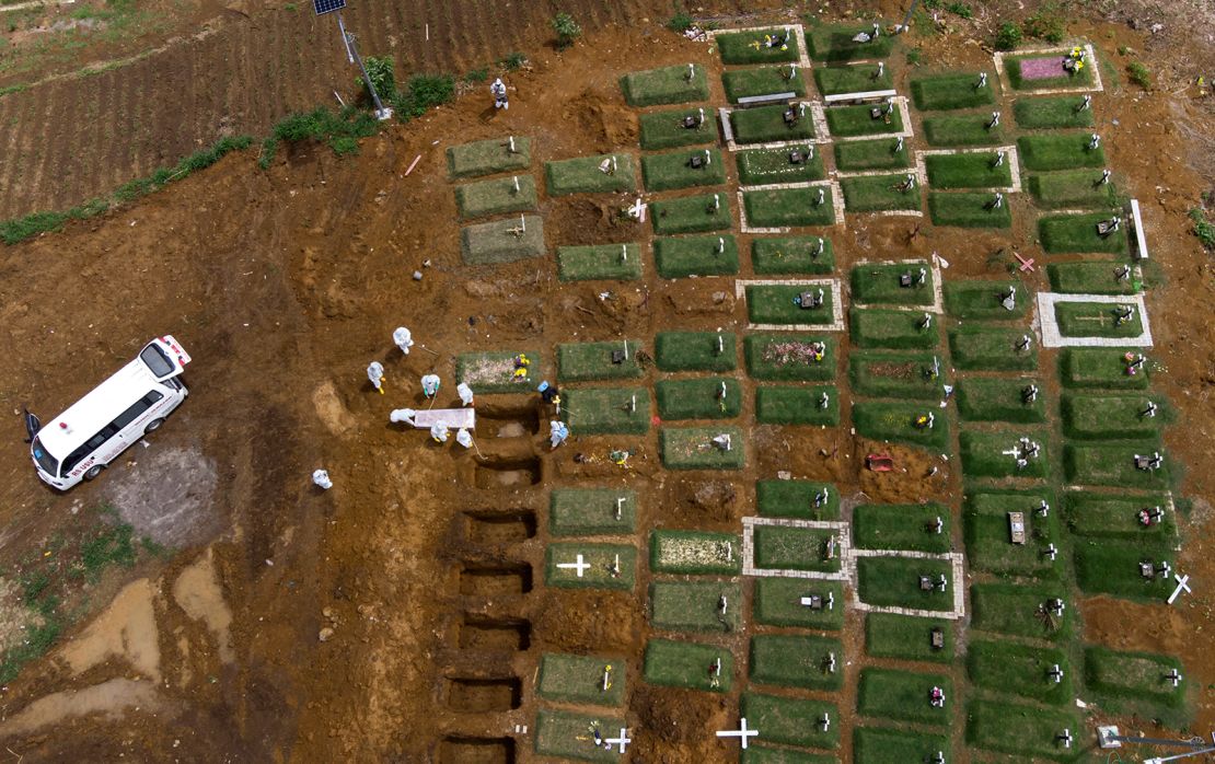 Workers bury a coffin containing the body of a Covid-19 victim at a cemetery reserved for coronavirus deaths in North Sumatra, Indonesia.