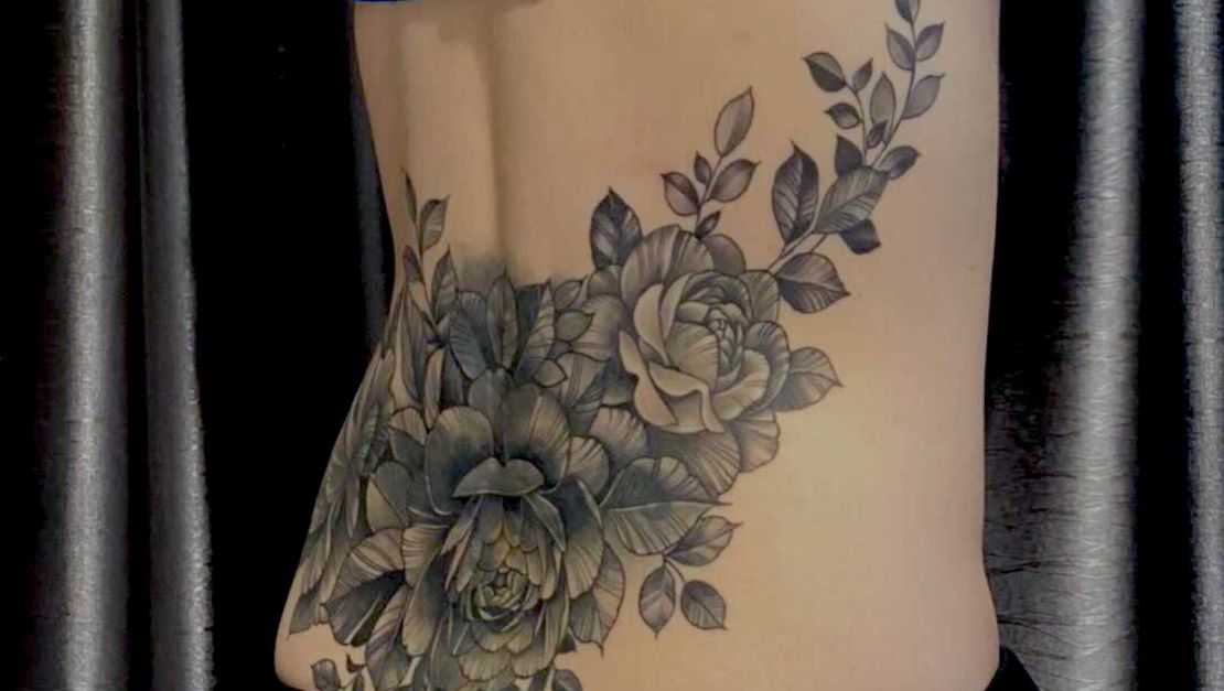 The writer opted to cover up her dated tattoo with a monochromatic floral collage. 