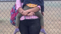 A Central American woman holds her child while waiting to be processed by US Border Patrol agents near the US-Mexico border on April 10, 2021, in La Joya, Texas.