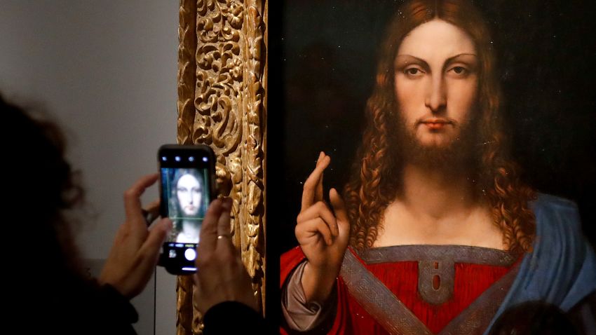 People take pictures with mobile phone of an oil painting by Atelier Leonardo da Vinci's  " Salvator Mundi" (Version Ganay), during the opening of the exhibition " Leonardo da Vinci ", on October 22, 2019 at the Louvre museum in Paris. - Five hundred years after the death of Leonardo da Vinci, the Louvre Museum inaugurates on October 23, 2019 the largest exhibition ever set up around the work of the genius of the Renaissance, which is already announced as a popular success. (Photo by Francois Guillot / AFP) / RESTRICTED TO EDITORIAL USE - MANDATORY MENTION OF THE ARTIST UPON PUBLICATION - TO ILLUSTRATE THE EVENT AS SPECIFIED IN THE CAPTION (Photo by FRANCOIS GUILLOT/AFP via Getty Images)