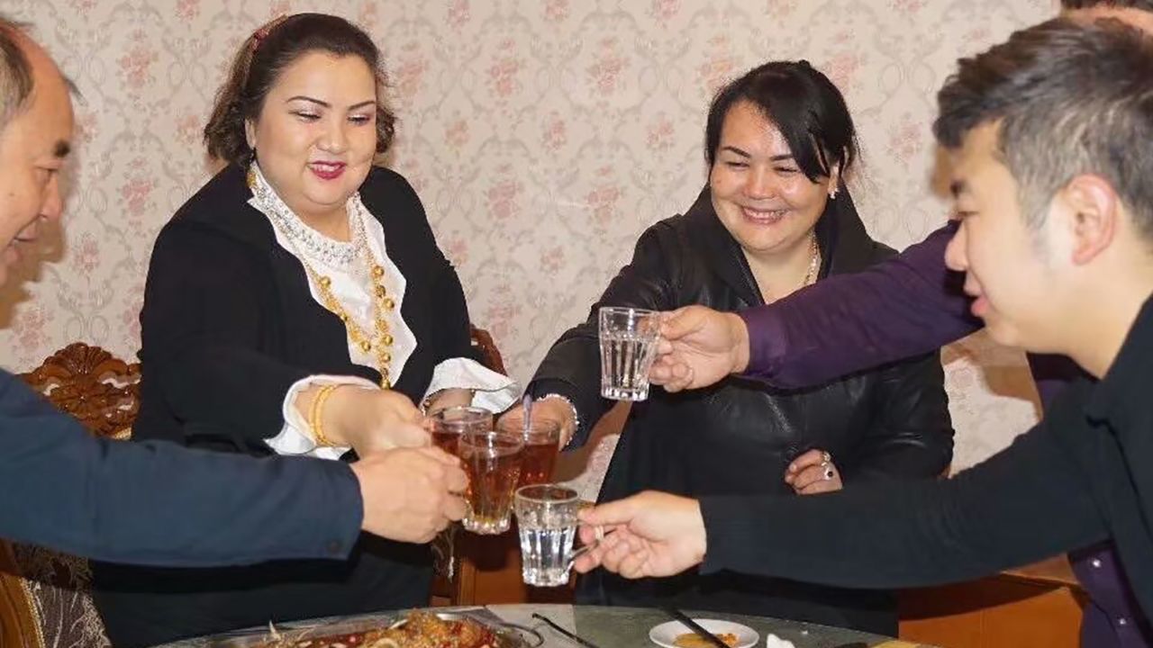 Uyghur Zumrat Dawut, second from left, says she hosted four cadres during each 10-day visit -- she and her four children were assigned one person each. 
