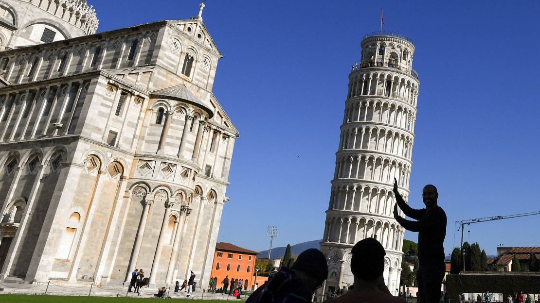 Tourists pose for photos with the Leaning Tower of Pisa in November 2018.