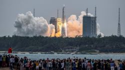 TOPSHOT - People watch a Long March 5B rocket, carrying China's Tianhe space station core module, as it lifts off from the Wenchang Space Launch Center in southern China's Hainan province on April 29, 2021. - China OUT (Photo by STR / AFP) / China OUT (Photo by STR/AFP via Getty Images)