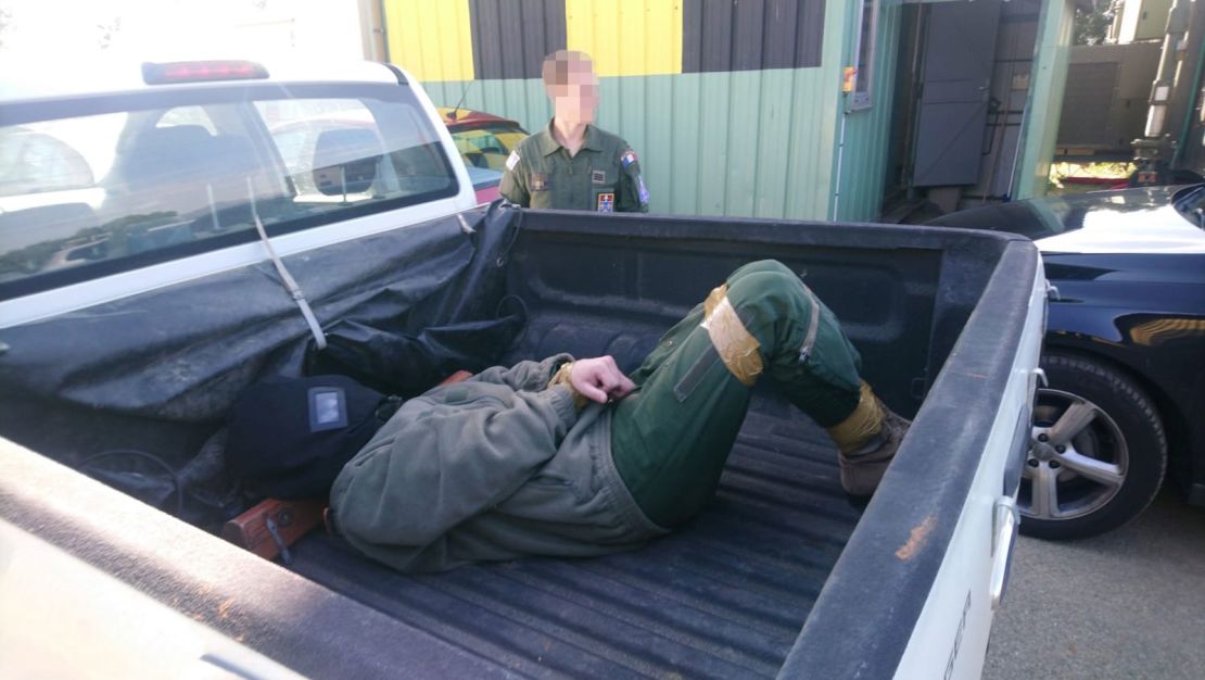 The alleged victim laying on the back of a pick-up truck with his legs and hands bound.