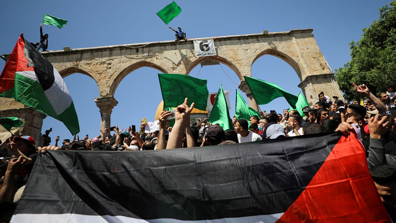 People hold flags as Palestinians gather after performing the last Friday of Ramadan to protest over the possible eviction of several Palestinian families from homes on land claimed by Jewish settlers in the Sheikh Jarrah neighbourhood, in Jerusalem's Old City, May 7, 2021. REUTERS/Ammar Awad