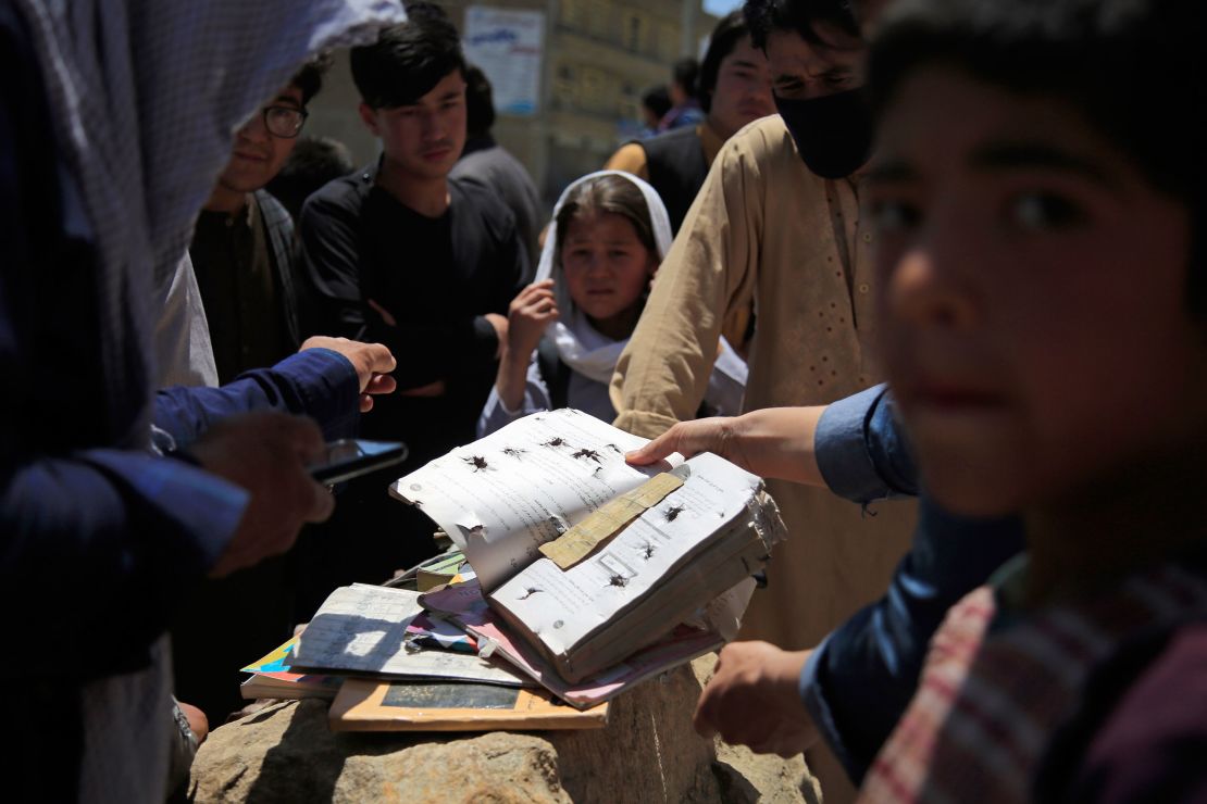 Afghans go through belongings left behind after the blasts on Saturday.
