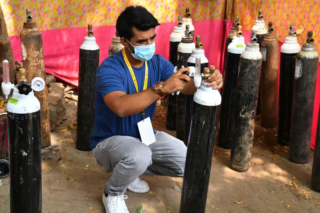 Shahnawaz Shaikh checks the pressure of an oxygen cylinder at a distribution center in Mumbai on April 28, 2021.