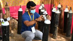 Local resident Shahnawaz Shaikh, who sold his SUV car to raise funds in order to start free service to provide oxygen cylinders to the needy people amid Covid-19 coronavirus pandemic, checks the pressure of an oxygen cylinder at a distribution centre in a slum in Mumbai on April 28, 2021. (Photo by Indranil MUKHERJEE / AFP) (Photo by INDRANIL MUKHERJEE/AFP via Getty Images)