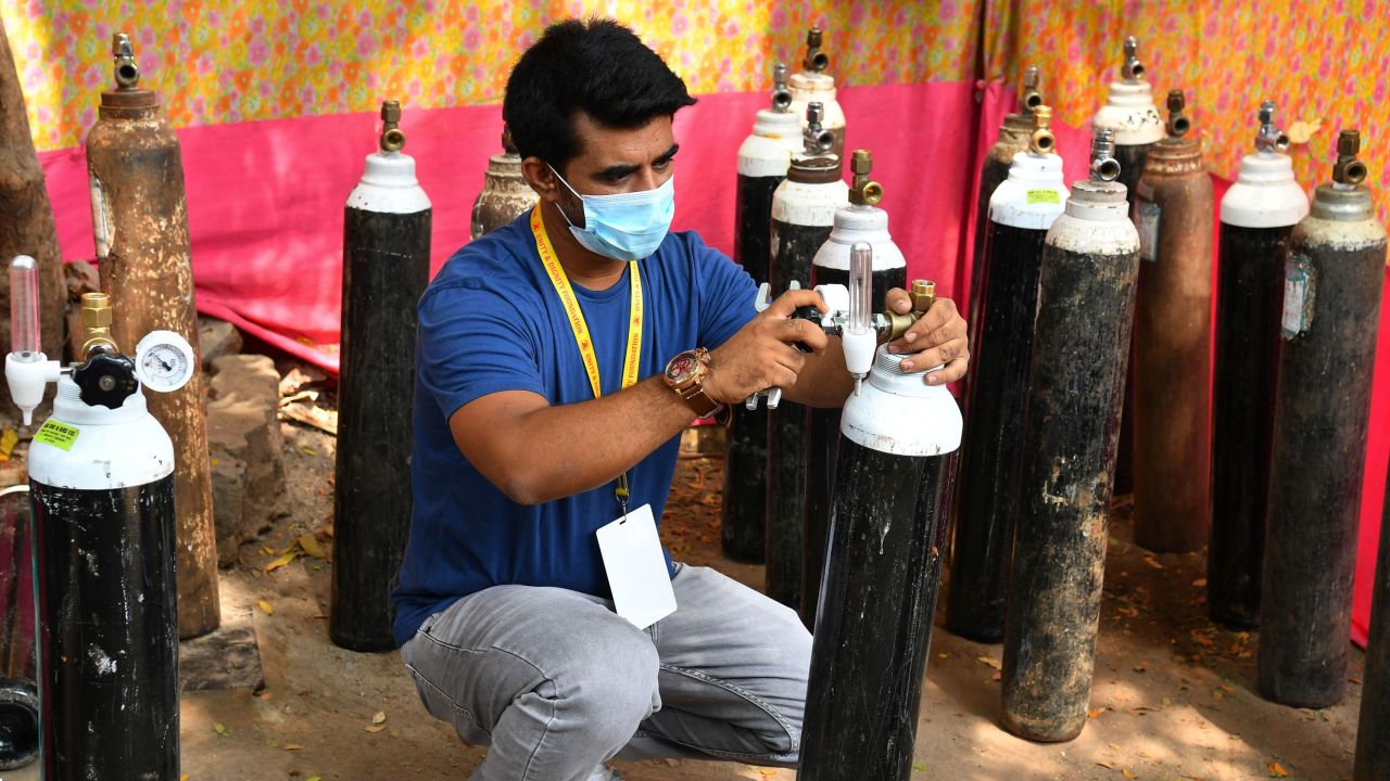 Shahnawaz Shaikh checks the pressure of an oxygen cylinder at a distribution center in Mumbai on April 28, 2021.