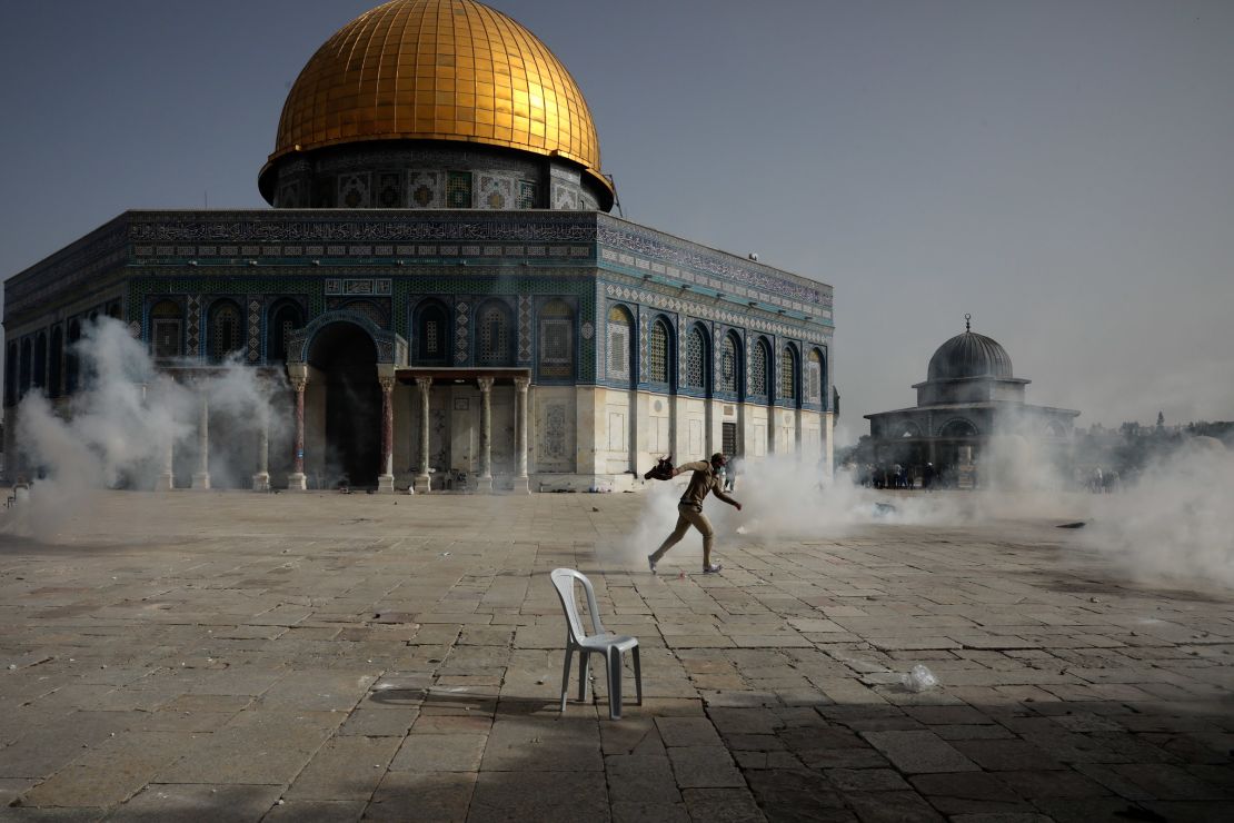 A Palestinian man runs from tear gas during clashes with Israeli security forces in front of the Dome of the Rock on Monday. 
