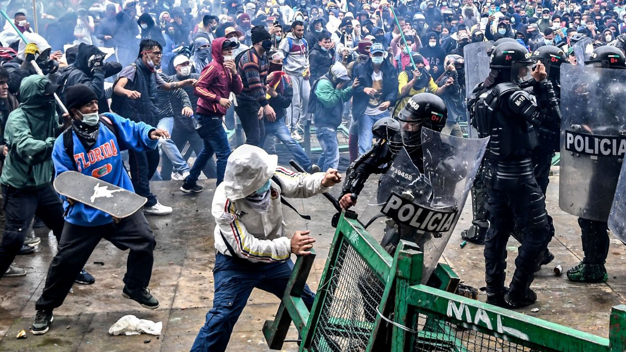 Demonstrators clash with riot police during a protest against a tax reform bill launched by Colombian President Ivan Duque, in Bogota, on April 28, 2021. 