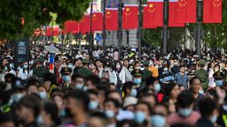People walk along a pedestrian street during a labour day holiday in Shanghai on May 1, 2021. (Photo by Hector RETAMAL / AFP) (Photo by HECTOR RETAMAL/AFP via Getty Images)