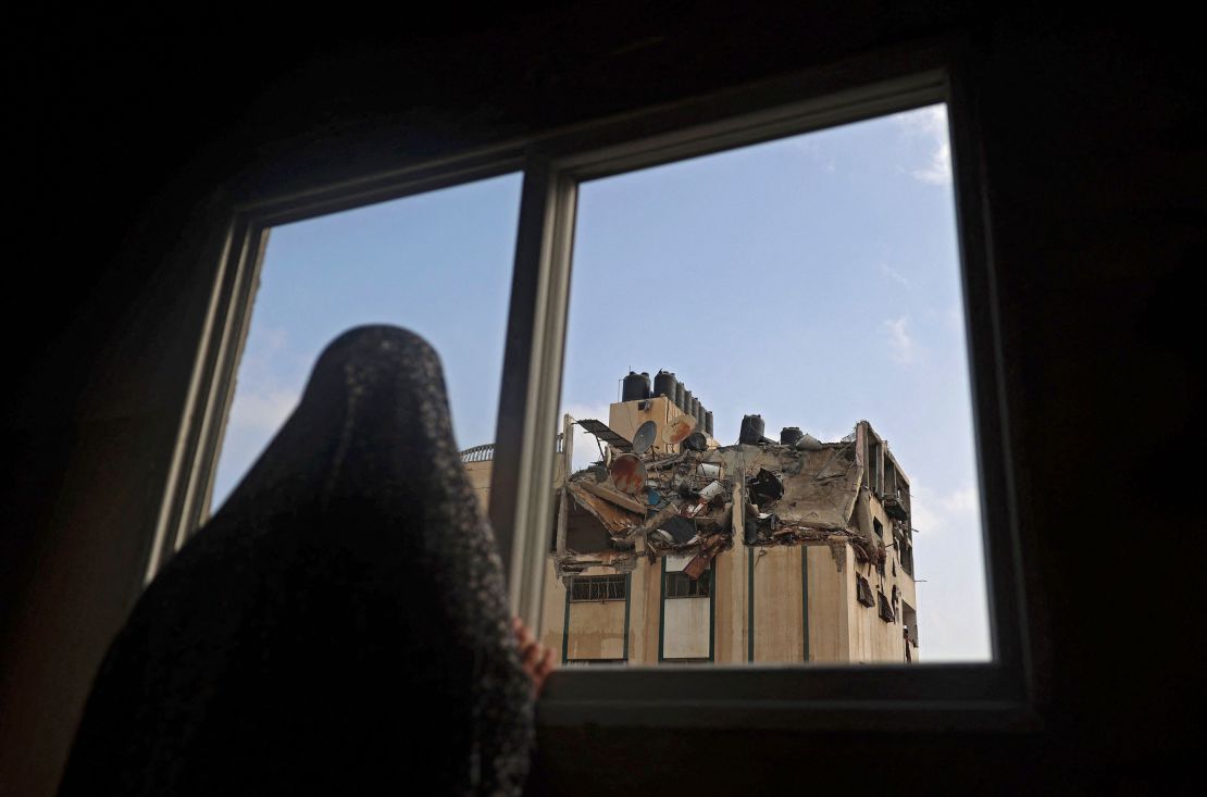 A Palestinian woman looks at the rooftop of a building which was hit by an Israeli airstrike at al-Shati Refugee Camp in Gaza City on Tuesday.