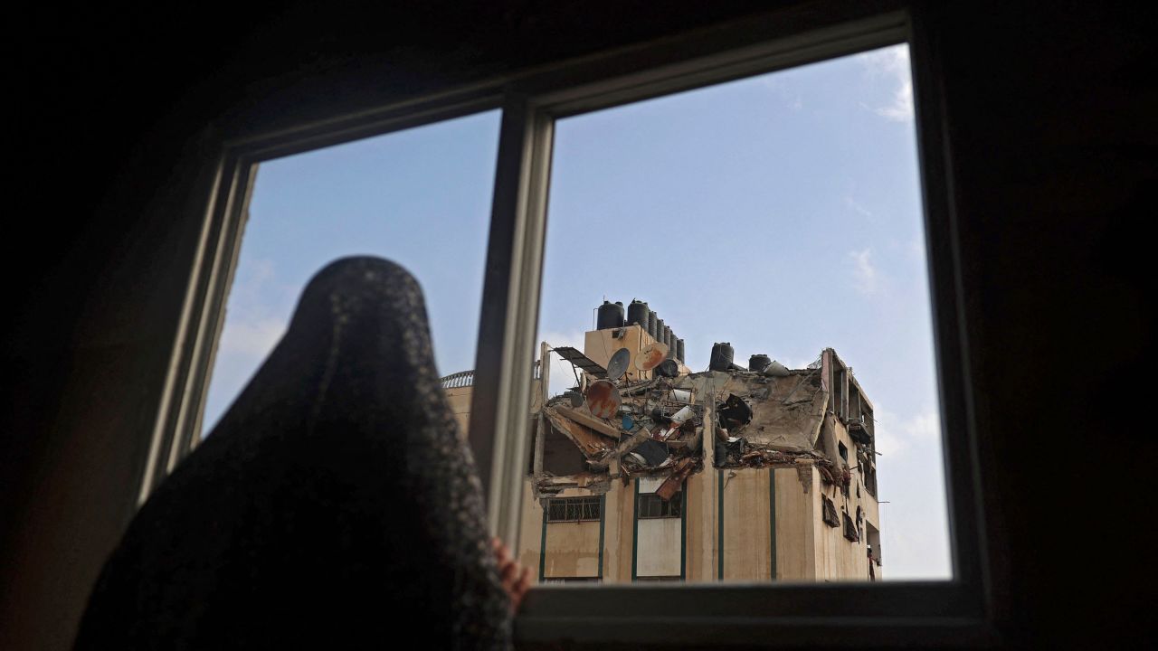 A Palestinian woman looks at the rooftop of a building which was hit by an Israeli airstrike at al-Shati Refugee Camp in Gaza City on Tuesday.