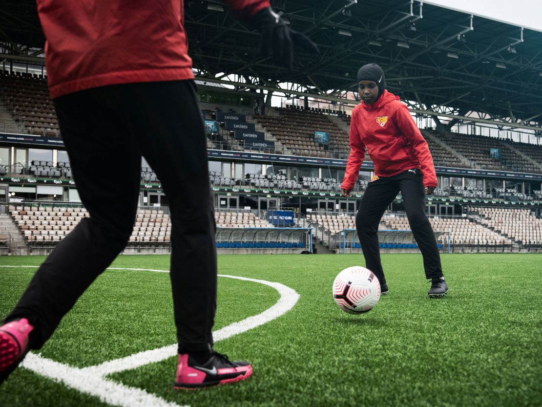 A player dribbles with a ball while wearing a Nike Pro hijab.