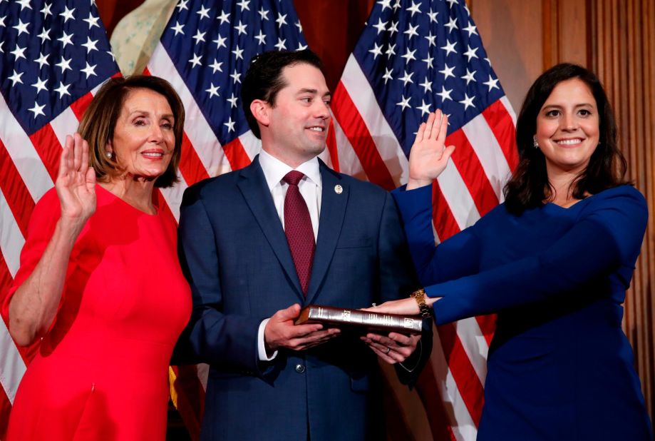 Stefanik's husband, Matthew Manda, holds the Bible as she is ceremonially sworn in by House Speaker Nancy Pelosi in January 2019. Stefanik had just won her third term in office.