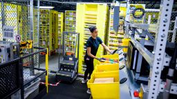 A woman works at a distrubiton station at the 855,000-square-foot Amazon fulfillment center in Staten Island, one of the five boroughs of New York City, on February 5, 2019. - Inside a huge warehouse on Staten Island thousands of robots are busy distributing thousands of items sold by the giant of online sales, Amazon. (Photo by Johannes EISELE / AFP)        (Photo credit should read JOHANNES EISELE/AFP via Getty Images)