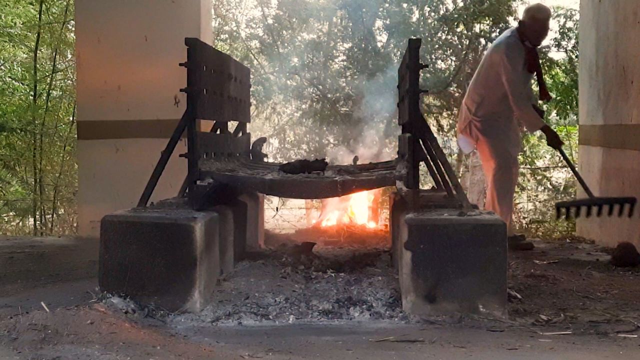 A volunteer performs cremations in the village of Chogath, Gujarat, on May 9.