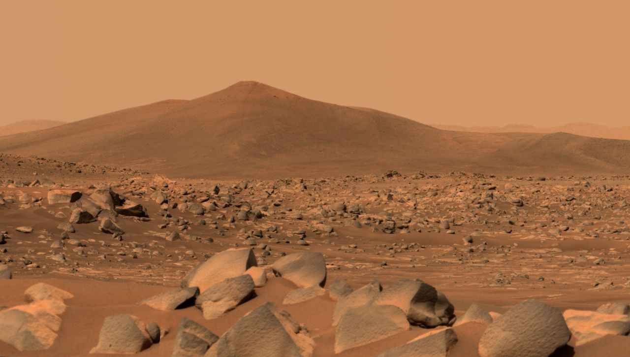 NASA's Perseverance Mars rover used its dual-camera Mastcam-Z imager to capture this image of "Santa Cruz," a hill about 1.5 miles (2.5 kilometers) away from the rover, on April 29, 2021, the 68th Martian day, or sol, of the mission. The entire scene is inside of Mars' Jezero Crater; the crater's rim can be seen on the horizon line beyond the hill.This scene is not white balanced; instead, it is displayed in a preliminary calibrated version of a natural-color composite, approximately simulating the colors of the scene as it would appear to a person on Mars. An enhanced color version is also included.