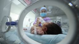 TOPSHOT - A medical staff member feeds a baby at a hospital in Danzhai, in China's southwestern Guizhou province on May 11, 2021. - China OUT (Photo by STR / AFP) / China OUT (Photo by STR/AFP via Getty Images)