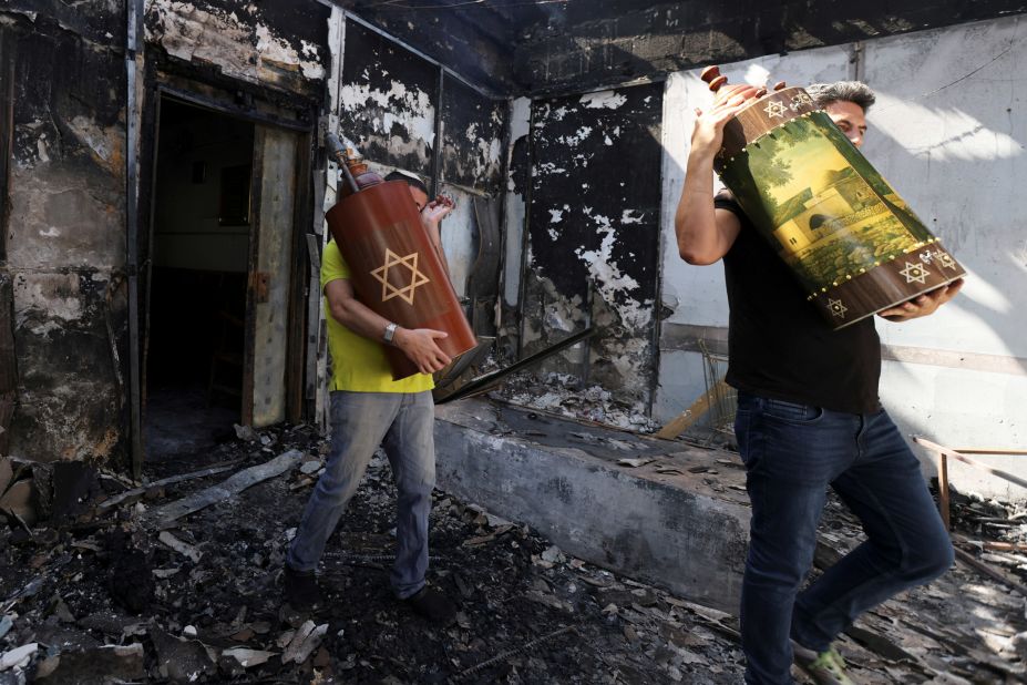 Torah scrolls, Jewish holy scriptures, are removed from a synagogue that was burned during confrontations between demonstrators and police in Lod, Israel, on May 12.