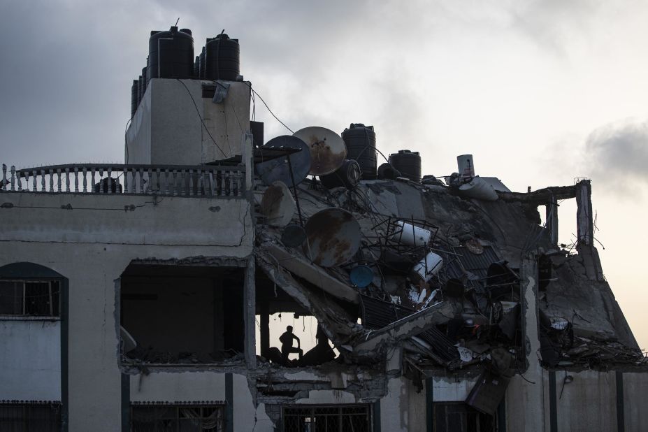 Palestinians search for survivors under the rubble of a destroyed rooftop after a residential building was hit by Israeli airstrikes at the Shate refugee camp in Gaza City on May 11.