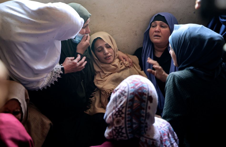 The mother of Palestinian Hussain Hamad, 11, is comforted by mourners during his funeral in Beit Hanoun, Gaza, on May 11. The boy was killed during fire between Israel and Gaza.