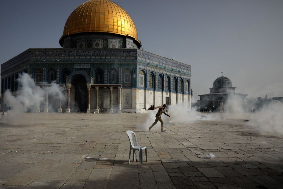 A Palestinian man runs from tear gas during clashes with Israeli security forces at the Aqsa Mosque compound in Jerusalem's Old City on May 10.
