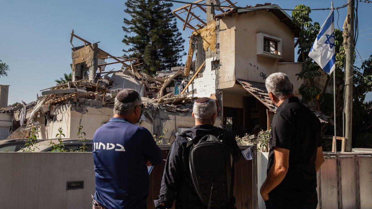 People look at a house Wednesday in Yehud, central Israel, after it was hit by a rocket fired from the Gaza Strip.