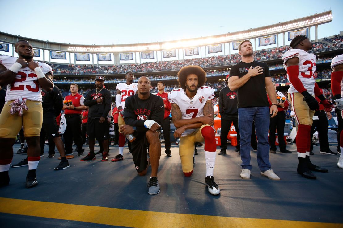 Eric Reid and Kaepernick kneel on the sideline during the national anthem.