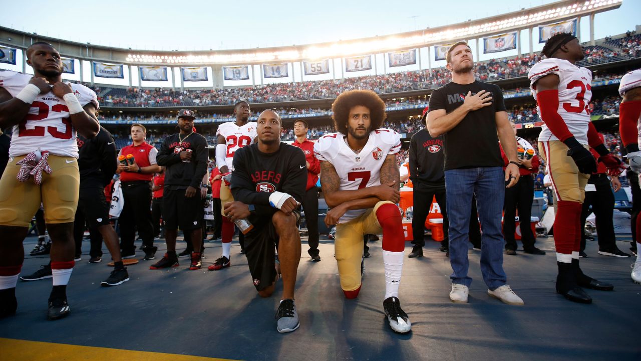 Eric Reid and Kaepernick kneel on the sideline during the national anthem.