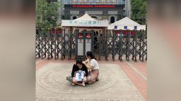  In a photo that was posted to the Chinese social media site Weibo, the the mother of Lin Weiqi (left), sits outside Chengdu No.49 High School holding a photo of her deceased son,  on Monday to demand answers for his tragic death.