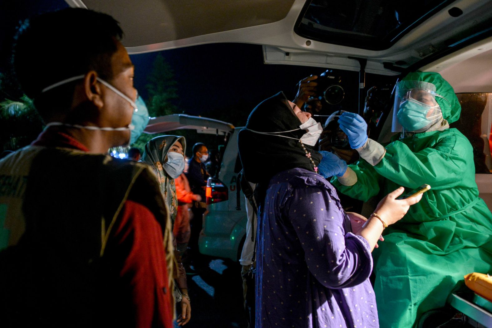 A health worker administers a Covid-19 test at a bus station in Banda Aceh, Indonesia, on May 3, ahead of Eid al-Fitr homecomings.