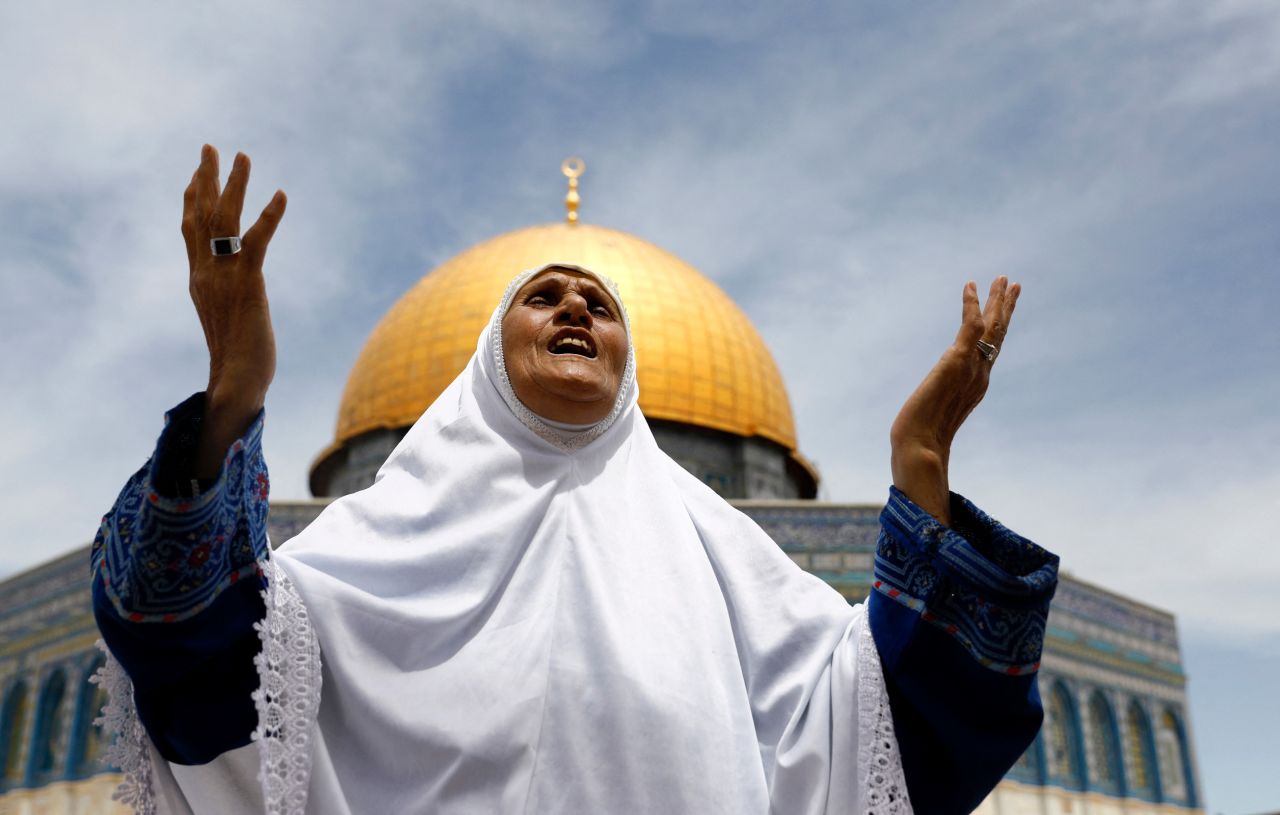 A woman prays outside the Dome of the Rock at Jerusalem's Al-Aqsa Mosque compound on Friday, May 7.