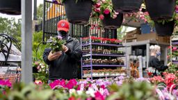 A customer wears a protective mask while looking at flowers in the garden center of a Home Depot Inc. store in Reston, Virginia, U.S., on Thursday, May 21, 2020. Home Depot Inc. this week fell as the cost of Covid-19 measures offset higher sales, tempering financial gains from renewed consumer interest in home-improvement projects. Photographer: Andrew Harrer/Bloomberg via Getty Images