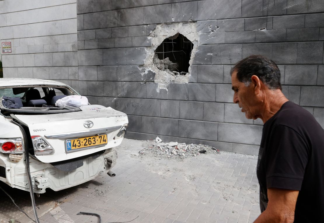 An Israeli man walks past the scene of a Palestinian rocket attack in the southern Israeli city of Ashkelon, on May 14.