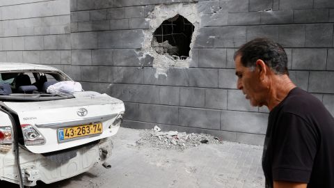 An Israeli man walks past the scene of a Palestinian rocket attack in the southern Israeli city of Ashkelon, on May 14.