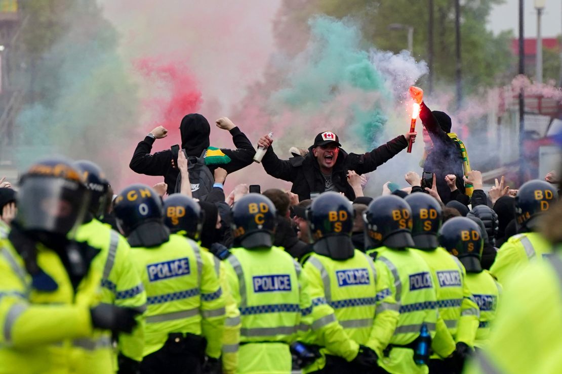 Manchester United fans holding flares protest against the Glazer family.