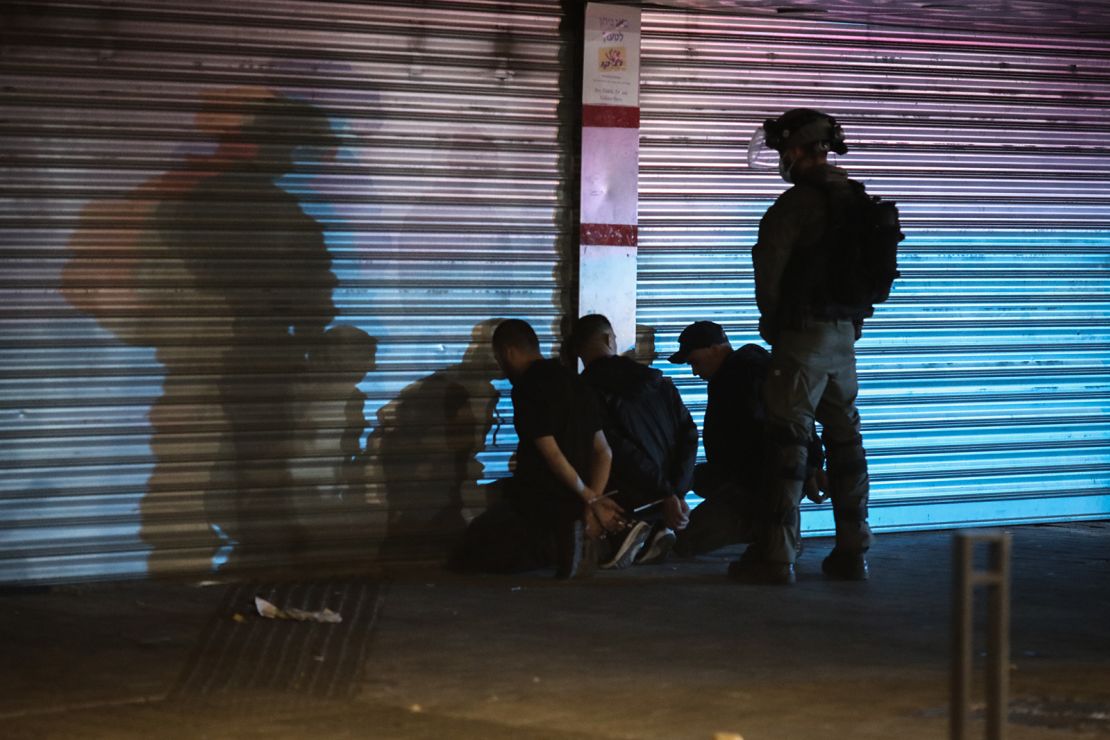 An Israeli security soldier detains three Arabs during clashes between Jews, Arabs and police in Lod on May 13.