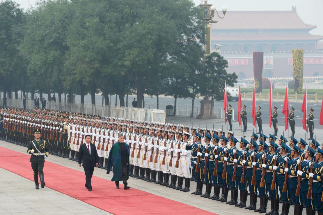Afghanistan's President Hamid Karzai walks with China's President Xi Jinping as they review an honour guard during a welcoming ceremony at the Great Hall of the People in Beijing on September 27, 2013.