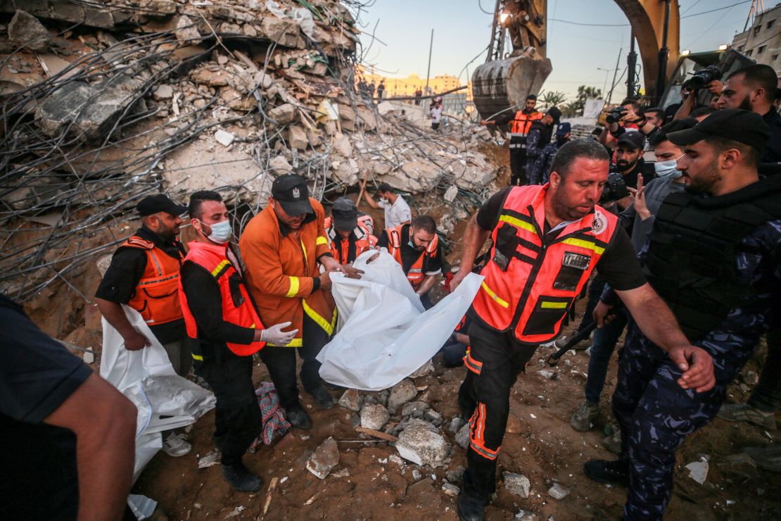 Palestinian civil defense teams take part in recovery efforts amid the rubble of a building after Israeli fighter jets conducted airstrikes in Beit Lahia, Gaza on May 13.