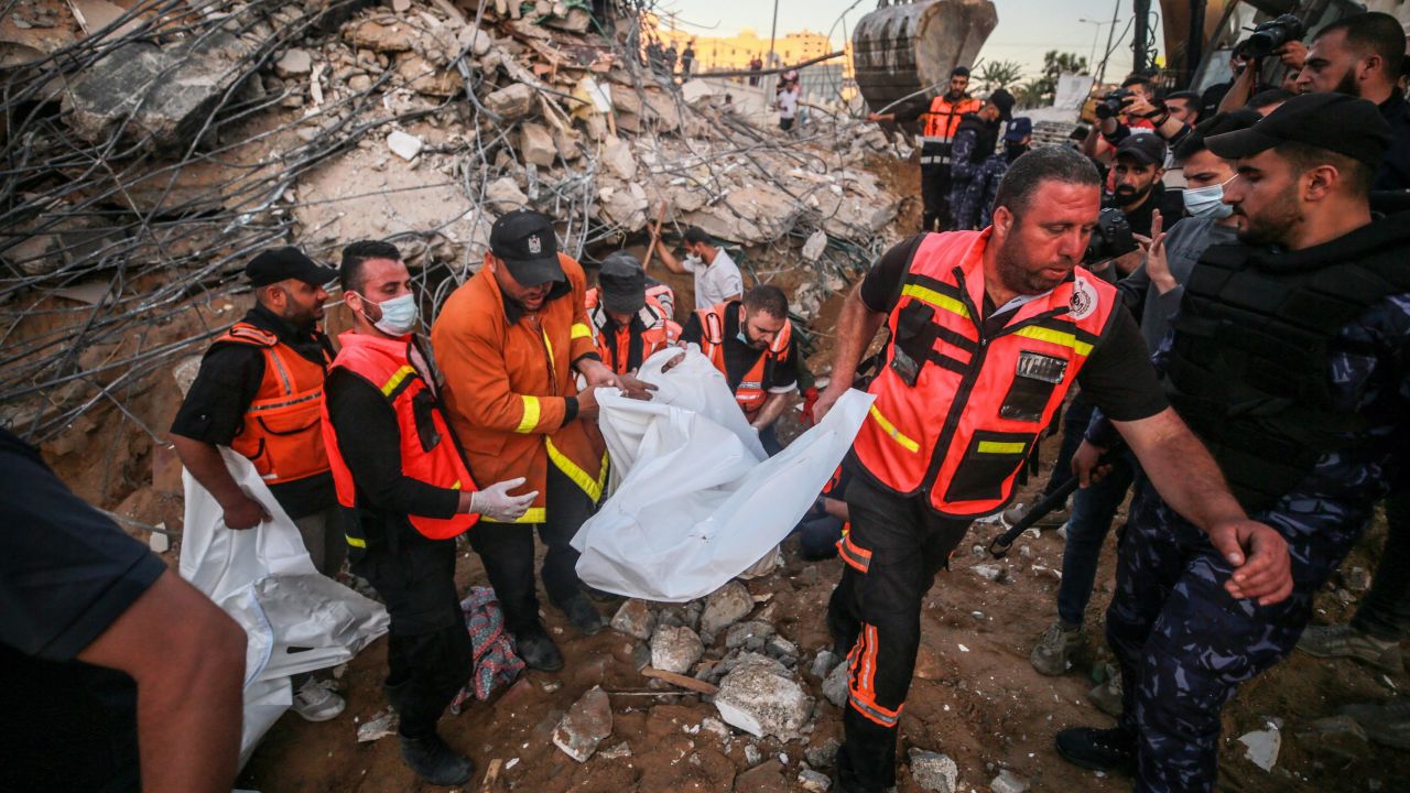 Palestinian civil defense teams take part in recovery efforts amid the rubble of a building after Israeli fighter jets conducted airstrikes in Beit Lahia, Gaza on May 13.