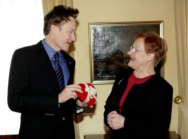 O'Brien hands a Valentine's Day present to Finnish President Tarja Halonen as he visited the presidential palace in Helsinki in 2006. O'Brien's resemblance to Halonen became a recurring bit on his show, and he eventually traveled to meet her and do a special episode from Finland.