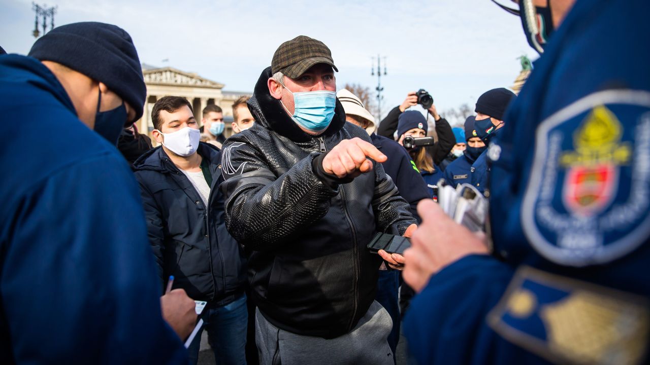 Police officers check a demonstrator during an anti-lockdown demonstration in Budapest, Hungary, on January 31, 2021.